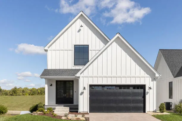 White board and batten facade with a black garage door, black and white contrast